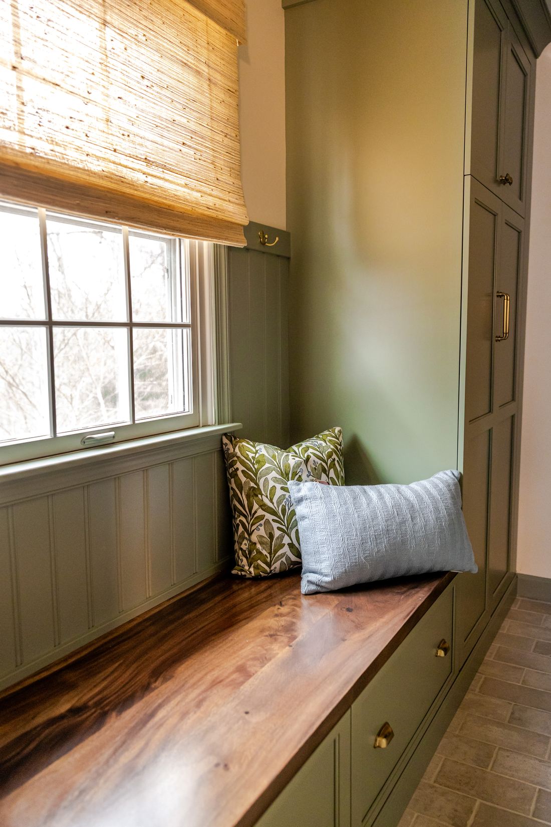Mudroom bench with sage green built-ins, live-edge wood seat and brick floor, Phoenix MD